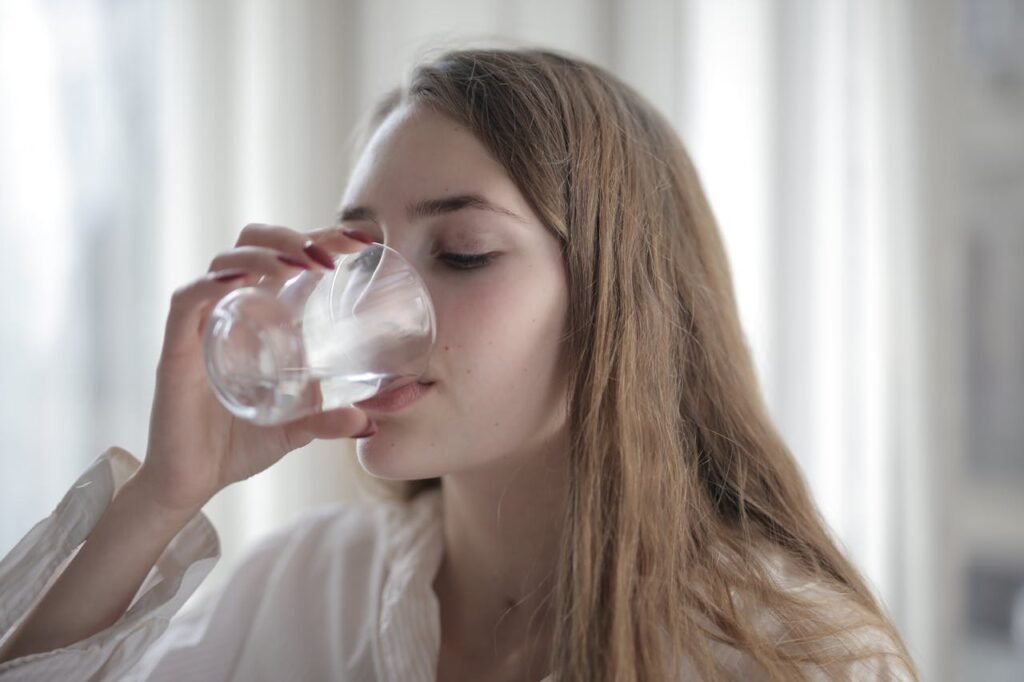 Mujer bebiendo agua alcalina con hidrógeno